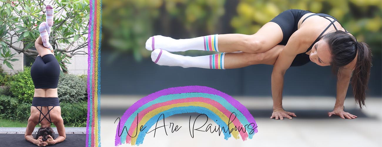 Mayasocks.com homepage image of Claire in headstand with eagle legs and side crow wearing crew length Rainbow pilates grip socks